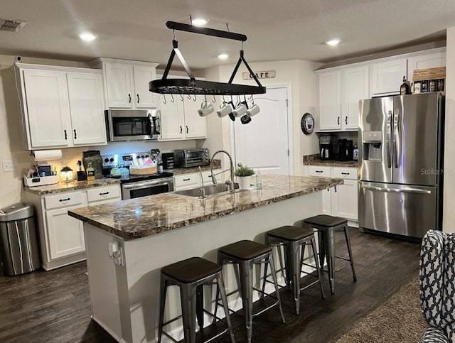 kitchen with visible vents, appliances with stainless steel finishes, white cabinetry, and a sink