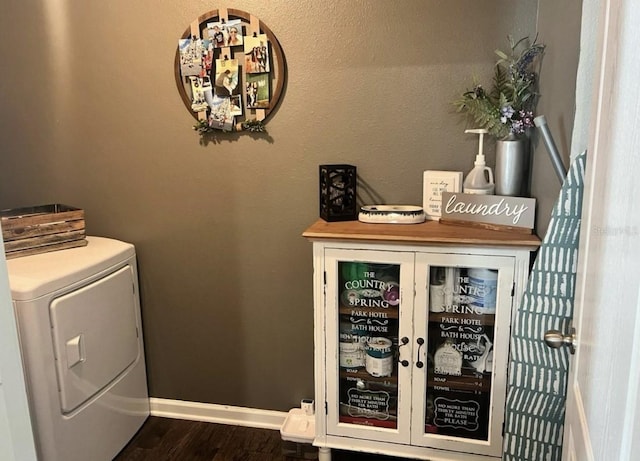 laundry area featuring baseboards, dark wood-style floors, and laundry area