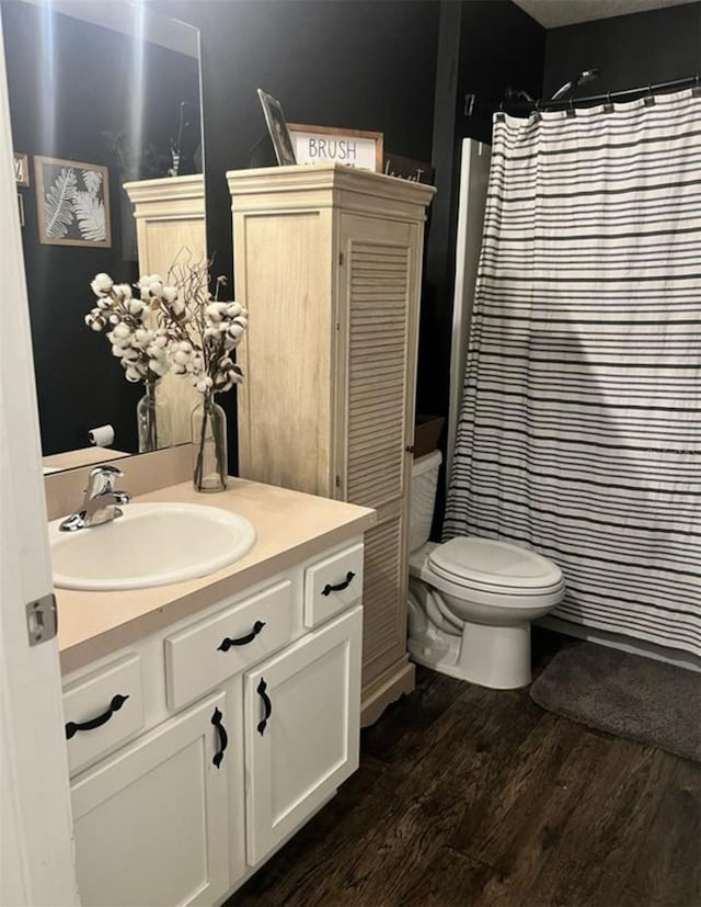 full bath with vanity, curtained shower, toilet, and wood finished floors