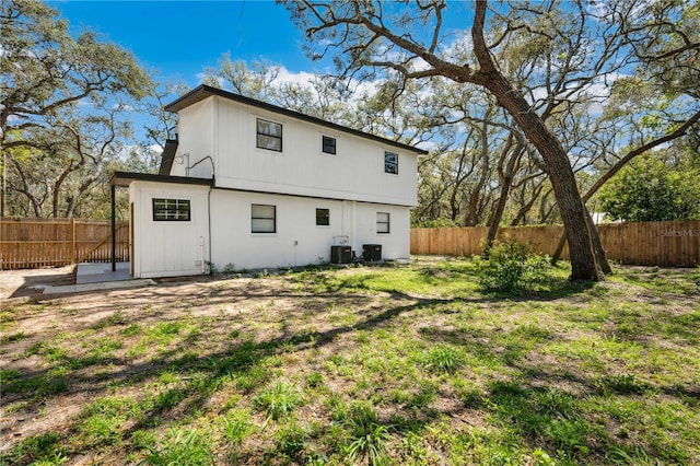 back of house featuring a lawn, cooling unit, and a fenced backyard