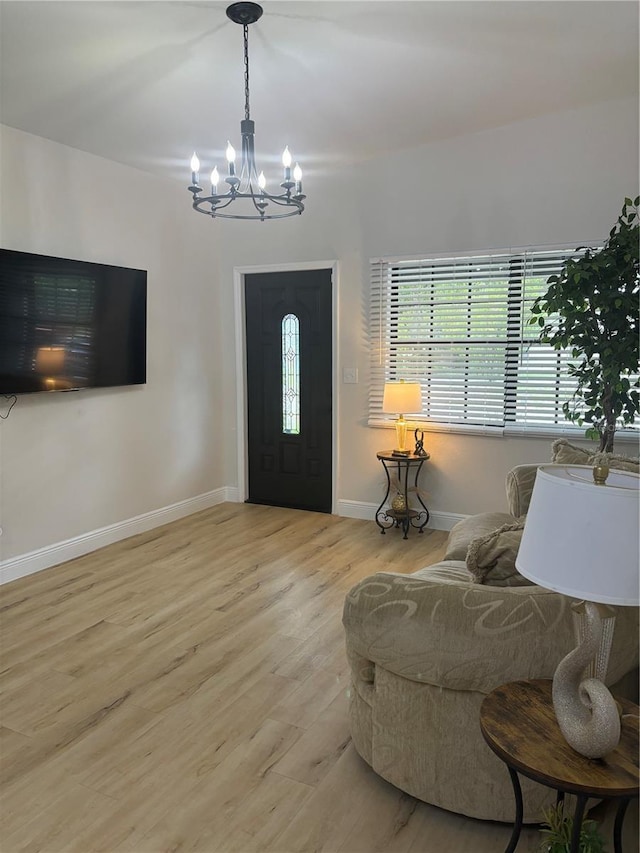 foyer featuring a chandelier, baseboards, and wood finished floors