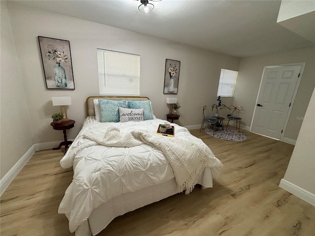 bedroom featuring baseboards and light wood-style floors