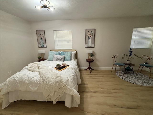 bedroom with baseboards and wood finished floors