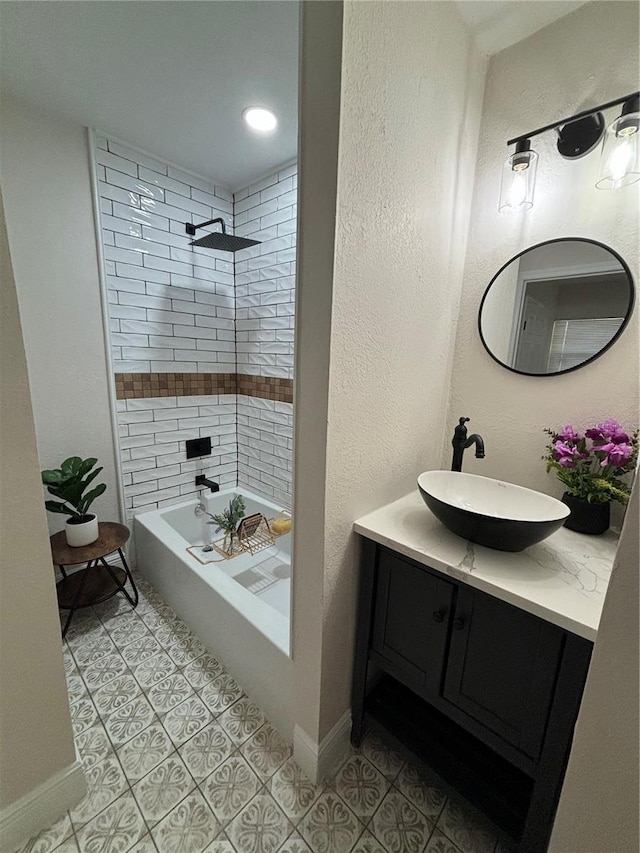 bathroom with tile patterned floors, baseboards, shower / washtub combination, and vanity