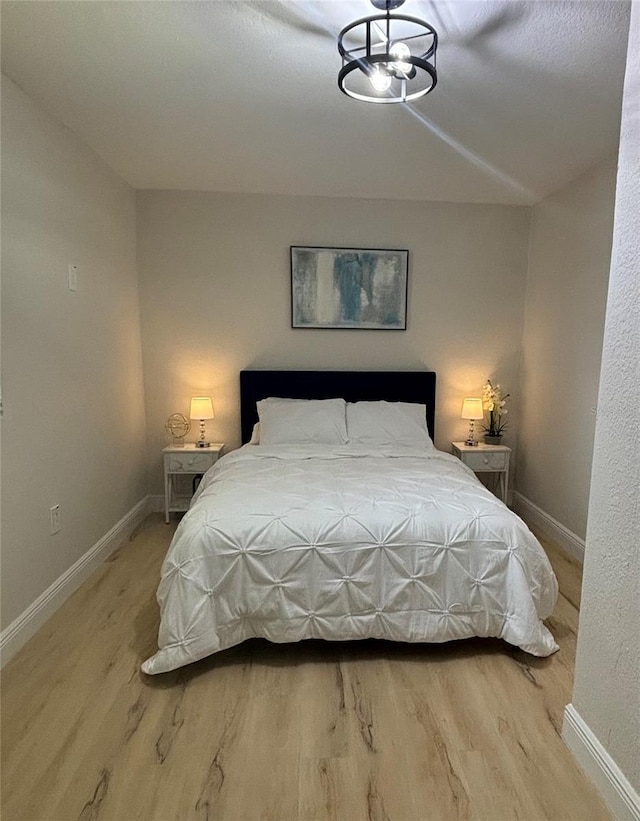 bedroom with light wood-style flooring and baseboards