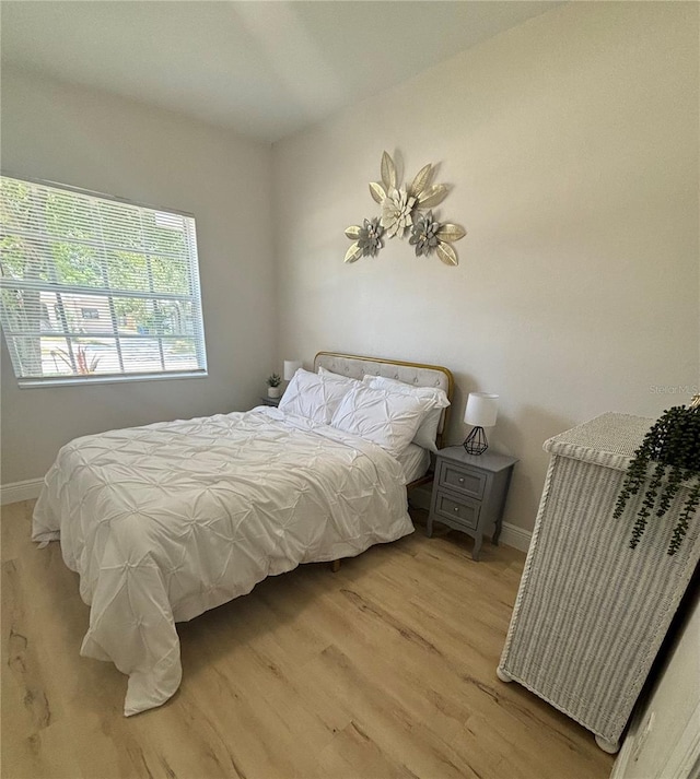 bedroom with baseboards and light wood-style floors