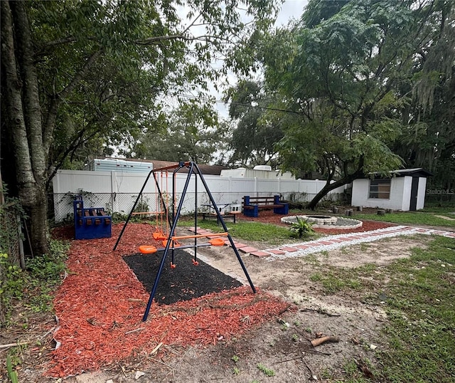 view of yard featuring an outbuilding, a playground, and a fenced backyard