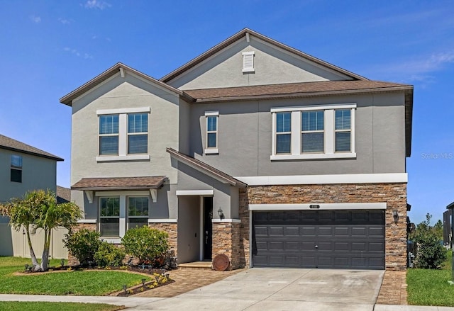 view of front of home featuring concrete driveway, an attached garage, stone siding, and stucco siding