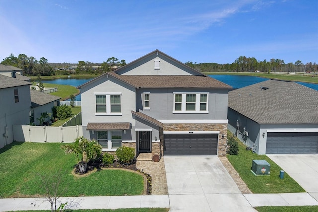 traditional-style home featuring a front lawn, fence, concrete driveway, stone siding, and a gate