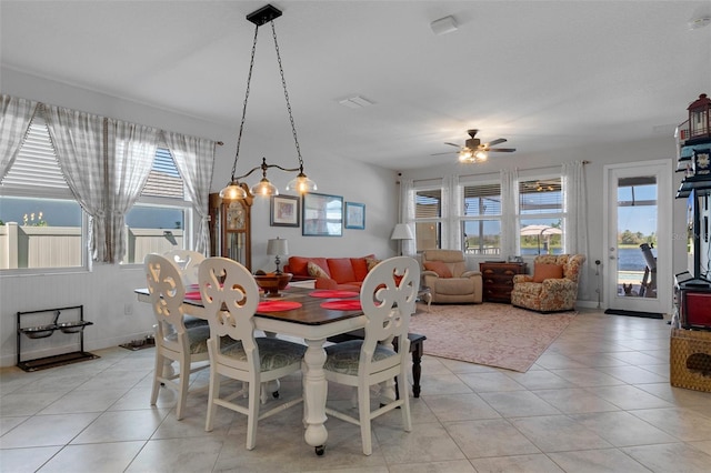 dining area featuring light tile patterned floors, baseboards, and a ceiling fan