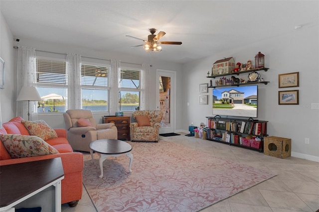 tiled living room featuring a ceiling fan and baseboards