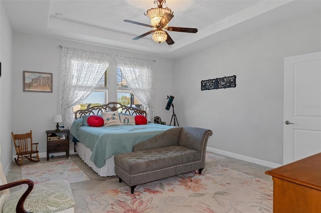 bedroom featuring baseboards, a raised ceiling, and ceiling fan