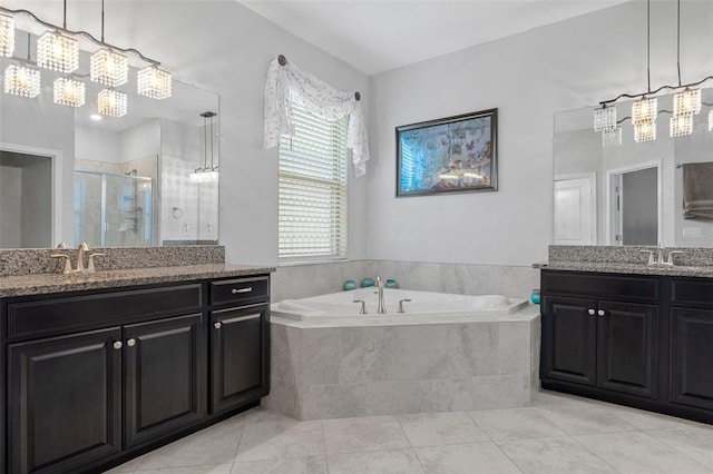 full bath featuring a sink, two vanities, a stall shower, and a bath