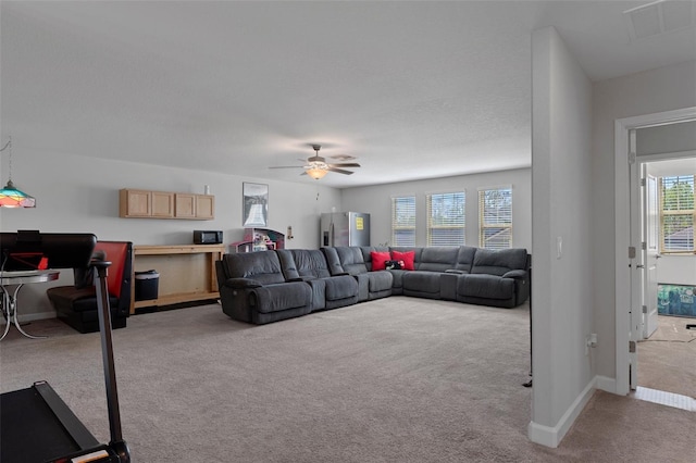 living room with a ceiling fan, carpet, visible vents, and baseboards