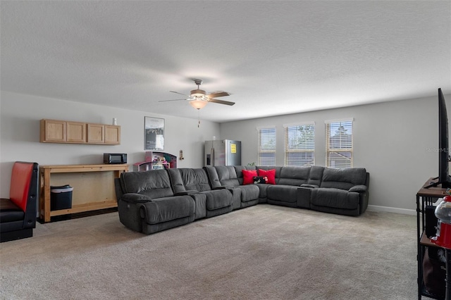 carpeted living room with baseboards, a textured ceiling, and a ceiling fan