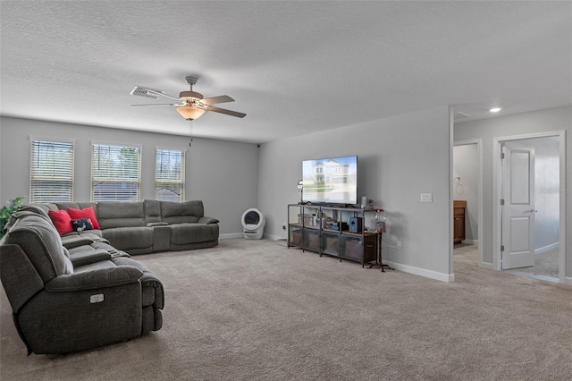 living room with carpet, visible vents, baseboards, ceiling fan, and a textured ceiling