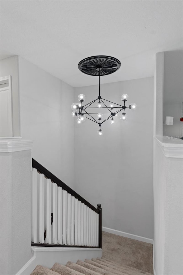 staircase featuring a notable chandelier, carpet, and baseboards