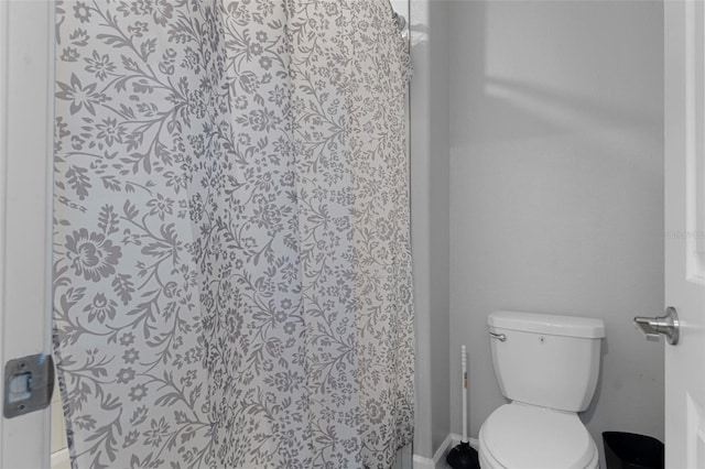 bathroom with a shower with shower curtain and toilet