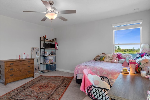 carpeted bedroom featuring baseboards and ceiling fan