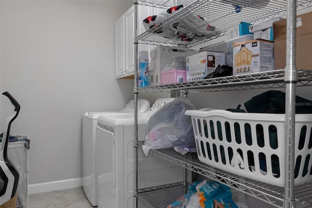 washroom with baseboards, cabinet space, and washer and clothes dryer