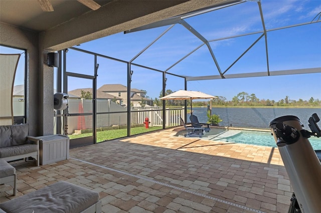 view of patio / terrace with glass enclosure, a fenced in pool, and a water view