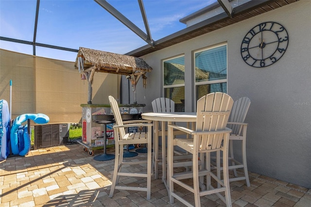 view of patio featuring central air condition unit, glass enclosure, and outdoor dining space