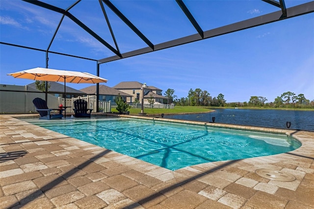 outdoor pool featuring glass enclosure, a patio, and a water view