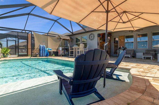 pool featuring glass enclosure, a ceiling fan, and a patio