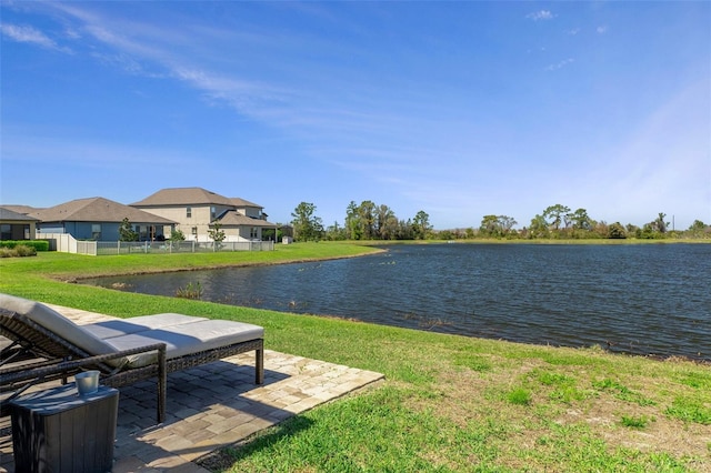 view of yard featuring a patio, fence, and a water view