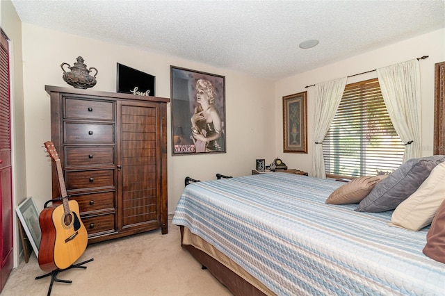 bedroom featuring light colored carpet and a textured ceiling