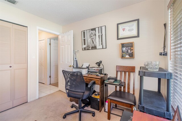 office area featuring carpet, visible vents, and a textured ceiling