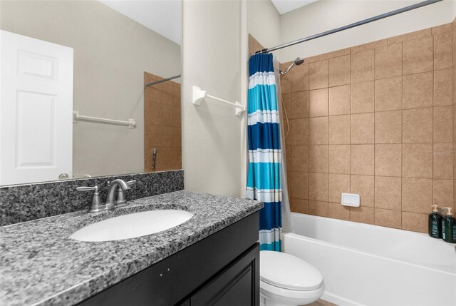 bathroom featuring toilet, vanity, and shower / tub combo with curtain