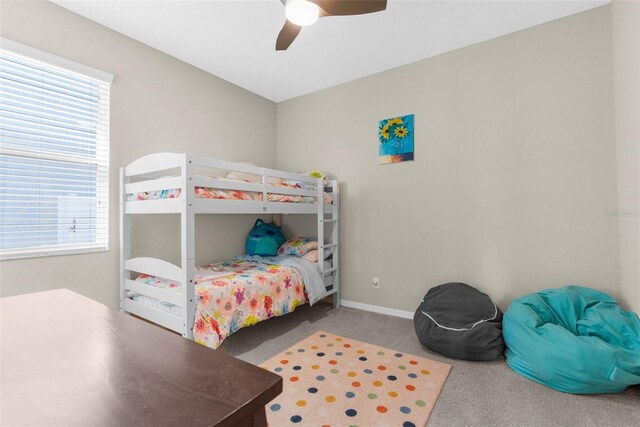 carpeted bedroom featuring baseboards and ceiling fan