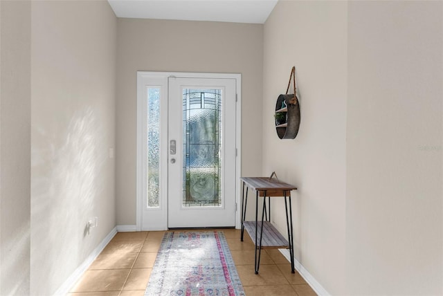 foyer entrance featuring light tile patterned floors and baseboards