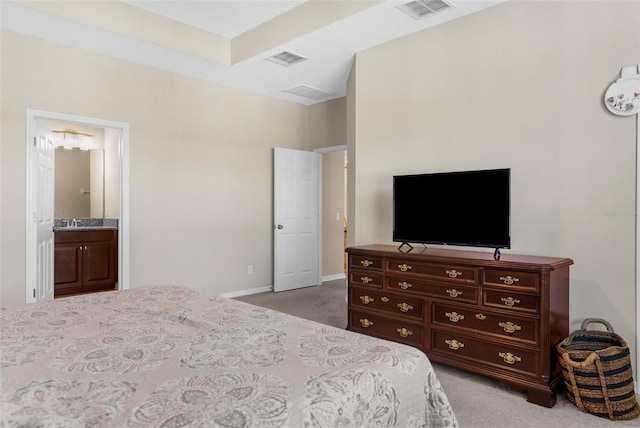 bedroom with a sink, visible vents, and light carpet