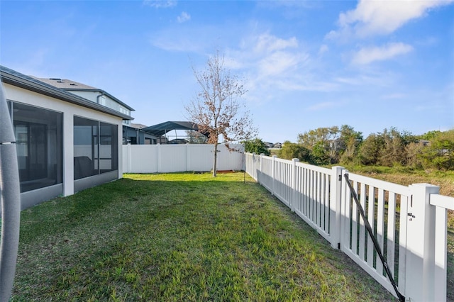 view of yard featuring a fenced backyard and a sunroom