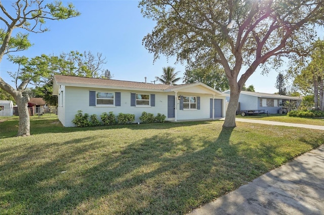 ranch-style house featuring a garage, concrete driveway, a front yard, and fence