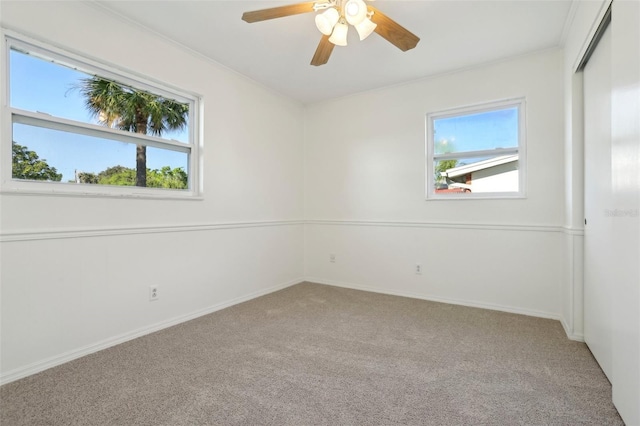 empty room featuring baseboards, carpet floors, and ceiling fan