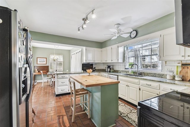 kitchen with tasteful backsplash, black range with electric stovetop, butcher block countertops, fridge with ice dispenser, and a sink