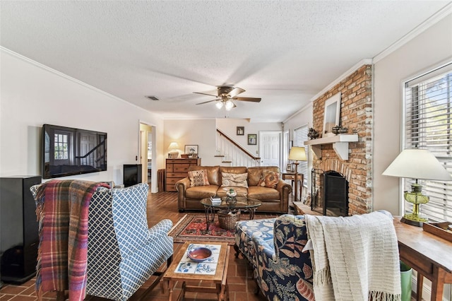 living area featuring visible vents, ornamental molding, wood finished floors, a fireplace, and stairs