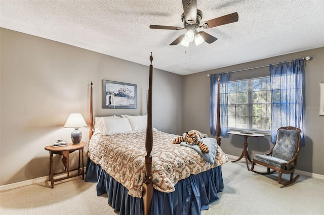 bedroom featuring ceiling fan, light colored carpet, baseboards, and a textured ceiling