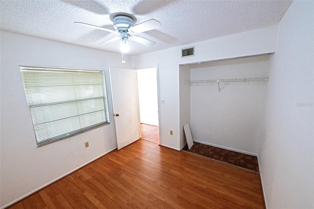 6125 113th St Unit 505, Seminole, FL 33772 - unfurnished bedroom with wood finished floors, a closet, a textured ceiling, and ceiling fan