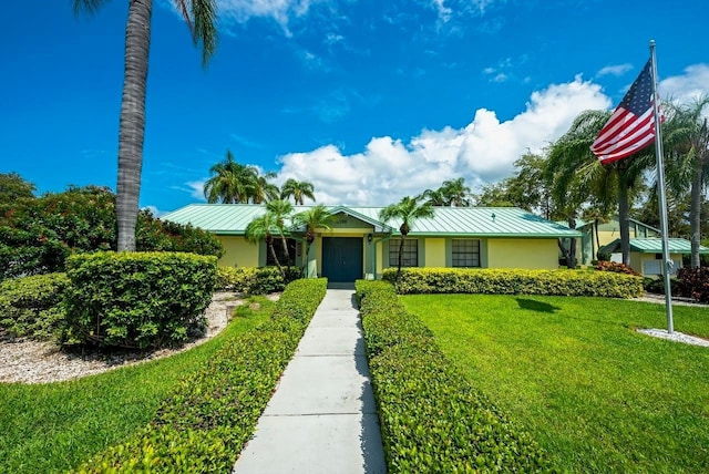 6125 113th St Unit 505, Seminole, FL 33772 - view of front of property featuring a front lawn, a metal roof, stucco siding, and a standing seam roof
