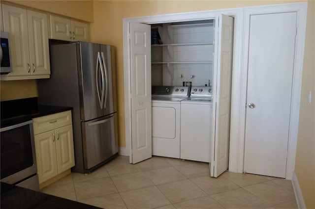 washroom featuring laundry area, light tile patterned floors, and independent washer and dryer