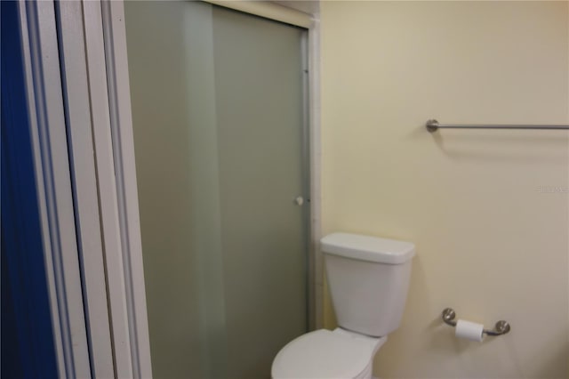 full bathroom featuring a stall shower and toilet