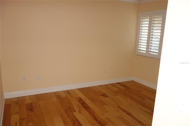 empty room featuring baseboards and light wood-type flooring