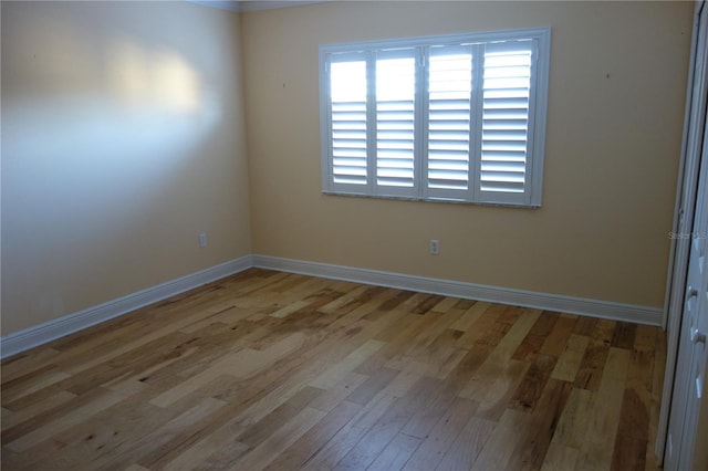 spare room with wood finished floors and baseboards