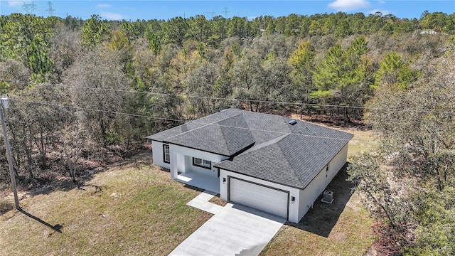 birds eye view of property featuring a view of trees