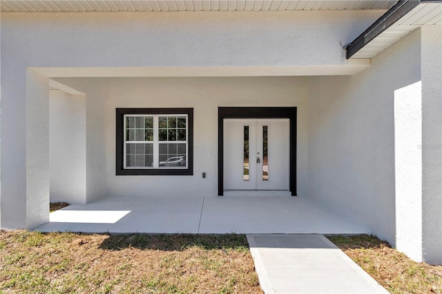 doorway to property with stucco siding and french doors