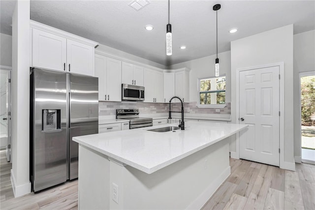 kitchen with a sink, decorative backsplash, white cabinetry, and stainless steel appliances